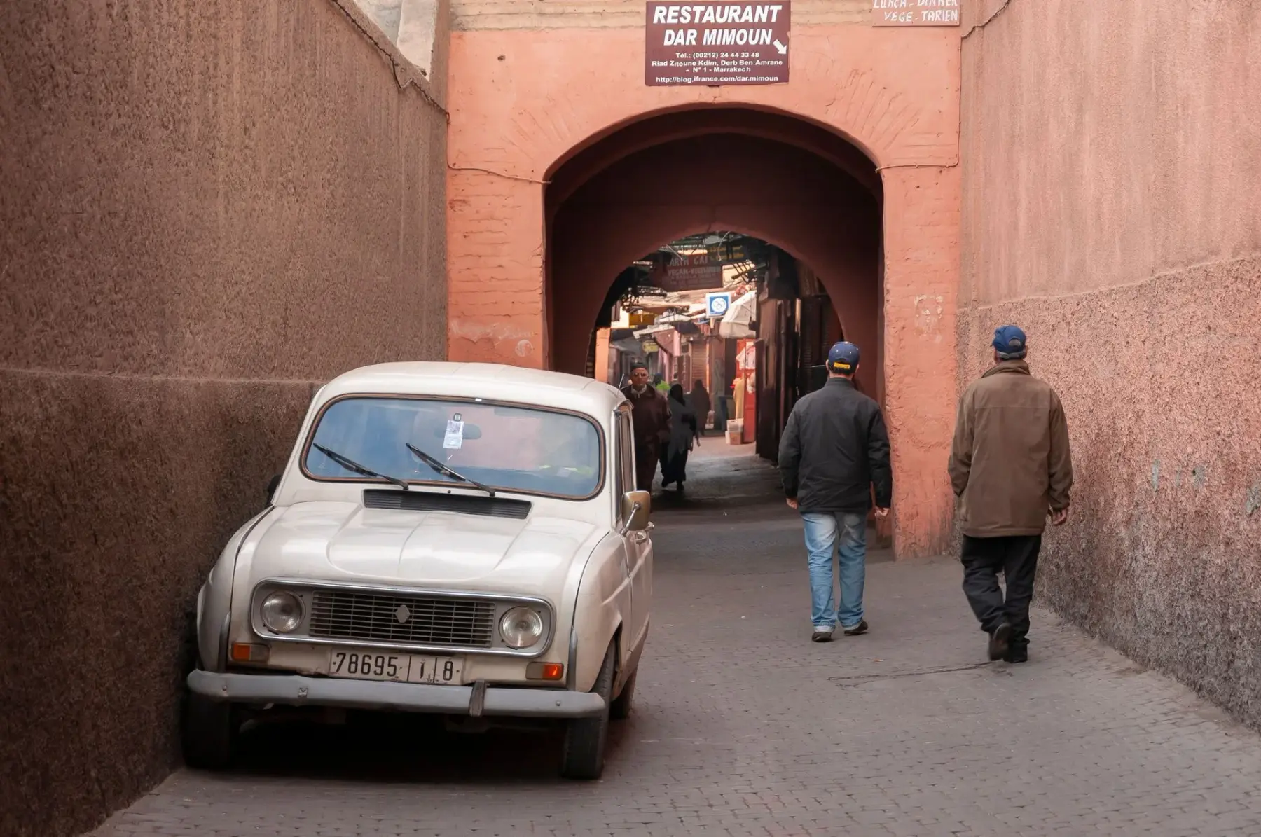Two men walking through an archway in the Marrakesh medina